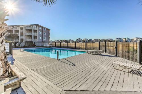 a swimming pool on a wooden deck with a fence at Condo with Pool Access - Walk to Beach! in Carolina Beach