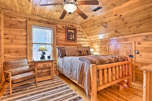 a bedroom with a bed and a chair in a log cabin at 'Sleeping Bear Cabin' Coosawattee! Dog Friendly! in Ellijay