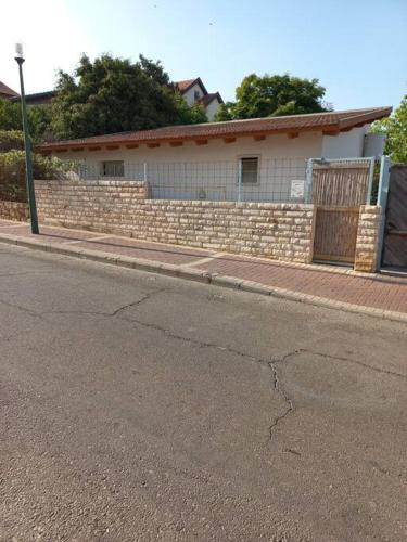 a building with a brick wall next to a street at בית הסוס in Nes Ẕiyyona