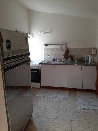 eine Küche mit weißen Schränken und einem Edelstahlofen in der Unterkunft בית הסוס in Nes Ẕiyyona