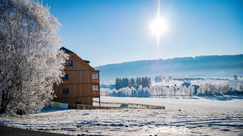 a building in the snow with the sun in the sky at Haus Weigt in Mariapfarr