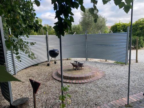 a fence with a grill and a picnic table at The Ruskamer Cottage at In the End in Stanford