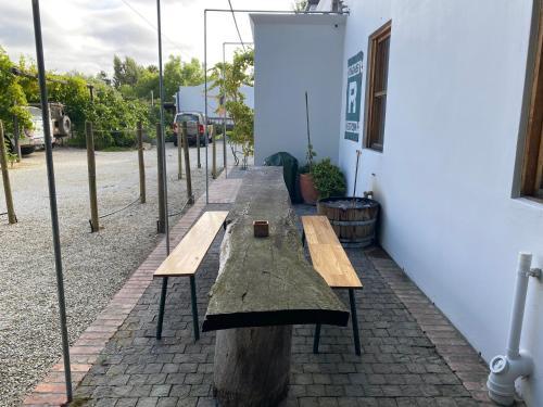 a row of wooden benches sitting next to a building at The Ruskamer Cottage at In the End in Stanford