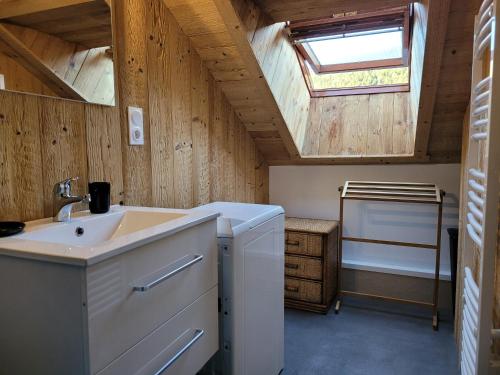 La salle de bains est pourvue d'un lavabo et d'une lucarne. dans l'établissement Beau duplex à proximité du lac de Gérardmer avec place de parking, à Gérardmer