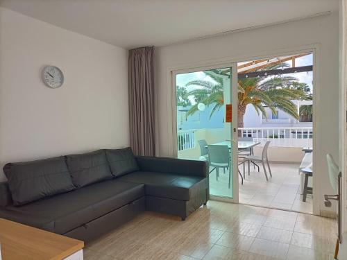 salon z kanapą i widokiem na patio w obiekcie CALIMA Lodge Corralejo w Corralejo