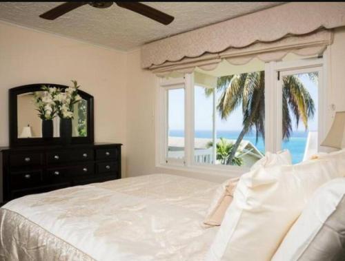 um quarto com uma cama grande e vista para o oceano em Ocho Rios 2 Bedroom Apartment/Flat em Ocho Rios