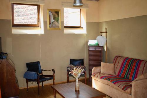 a living room with a couch and two chairs at Gîte l'Ecurie in Jodoigne