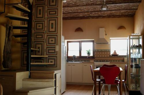 Gîte l'Ecurie في Jodoigne: مطبخ مع طاولة وكراسي في غرفة