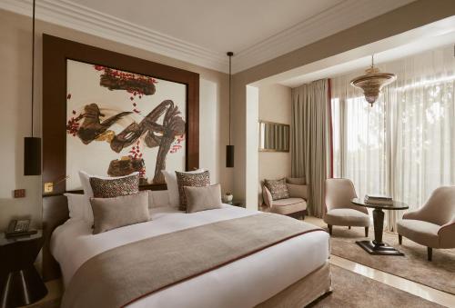 a bedroom with a large bed and a living room at Nobu Hotel Marrakech in Marrakech