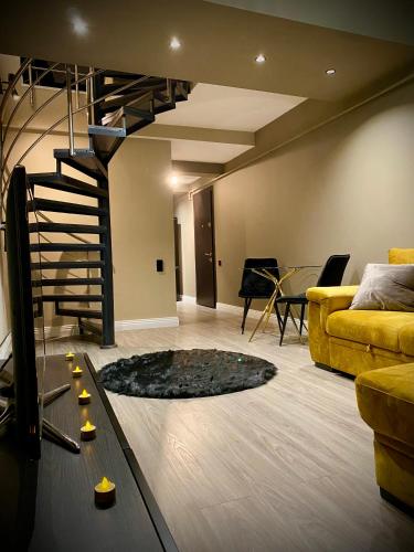 a living room with a couch and a spiral staircase at Cosmopolis Forever Friday Luxury in Ştefăneştii de Jos