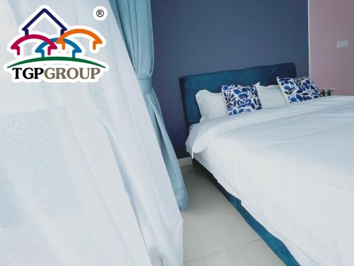a bedroom with a bed with a t top group sign on it at D'Pristine Design Apartment by TGP in Nusajaya