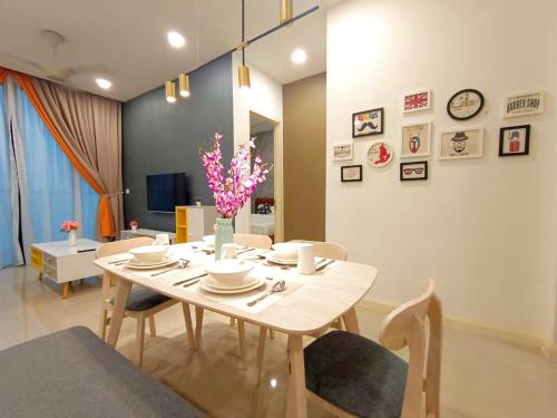 ein Esszimmer mit einem weißen Tisch und Stühlen in der Unterkunft D'Pristine Design Apartment by TGP in Nusajaya