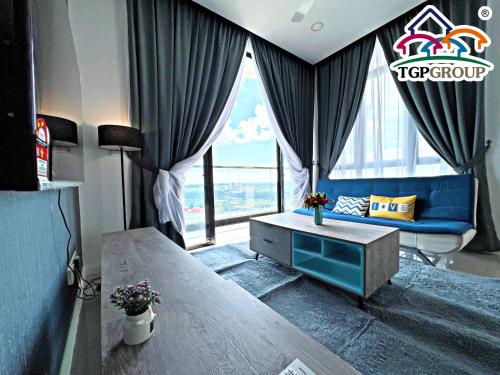 ein Wohnzimmer mit einem blauen Sofa und einem großen Fenster in der Unterkunft D'Pristine Design Apartment by TGP in Nusajaya