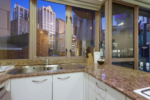 a kitchen with a sink and a large window at CBD Stunner - Skytower View - WIFI - Netflix in Auckland