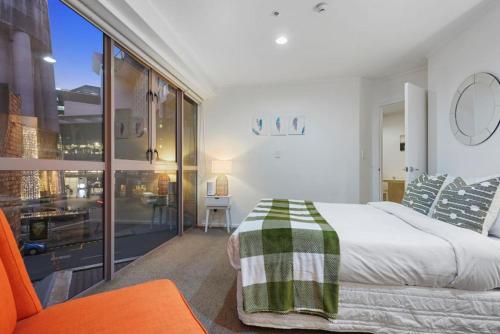 a bedroom with a bed and a large window at CBD Stunner - Skytower View - WIFI - Netflix in Auckland