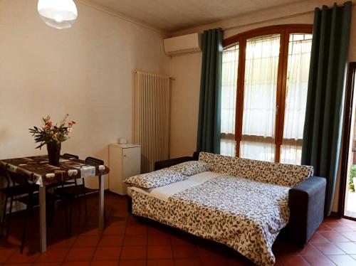 ボローニャにあるAppartamento Borghetto San Donatoのベッドルーム1室(ベッド1台、テーブル、窓付)