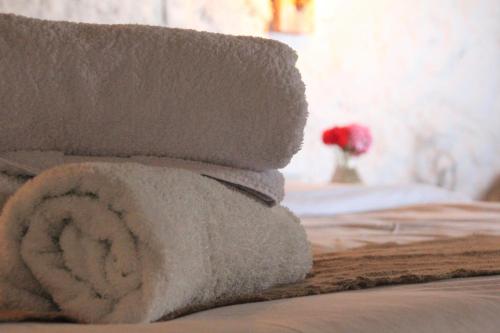 a pile of towels sitting on top of a bed at Hotel Fundo El Arrabal in Ica
