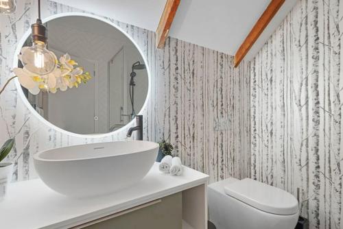 a bathroom with a sink and a mirror at Tranquil Sunset Retreat - Spa - WIFI - Netflix in Auckland