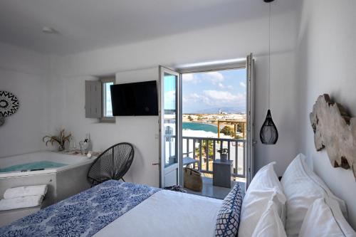 una camera con letto e vasca e un balcone di Angels Pillow Luxury Boutique Residence - Adults Only a Naoussa