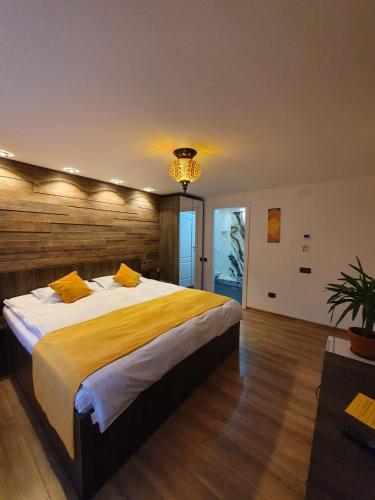 a bedroom with a large bed and a chandelier at Hanul Doftana in Trăisteni