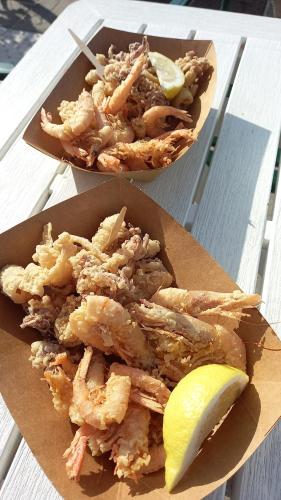 two plates of food with shrimp and a lemon on a table at Sea Horse in Lido di Camaiore