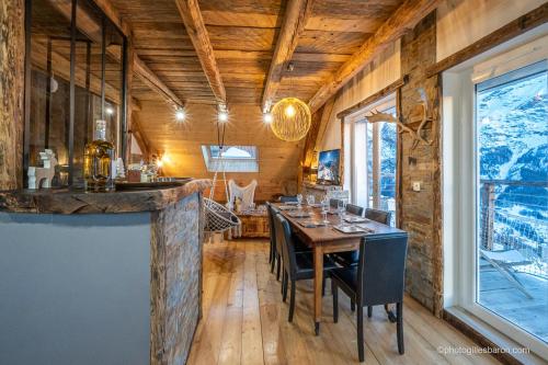 une salle à manger avec une table et une grande fenêtre dans l'établissement Appartement charmant à Orcières avec vue sur montagne, à Orcières