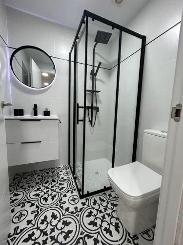 a bathroom with a shower and a toilet and a mirror at VIP -Apartamentos Birdie- in Albacete