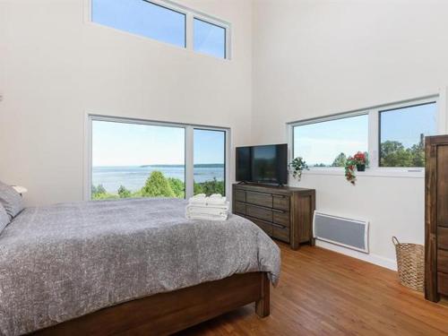 a bedroom with a bed and a flat screen tv at Auberge country inn in Baie-Saint-Paul