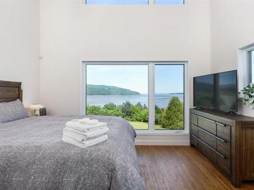 a bedroom with a bed and a large window at Auberge country inn in Baie-Saint-Paul