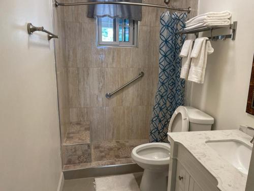 a bathroom with a shower with a toilet and a sink at Westmore Beach Villas Limited in Whitehouse