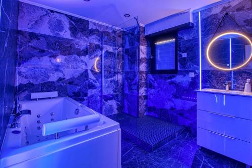 a purple bathroom with a tub and a shower at Appart Hotel avec Sauna, Jacuzzi, in Strasbourg