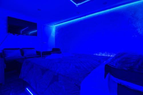a room with a bed with a blue light at Appart Hotel avec Sauna, Jacuzzi, in Strasbourg