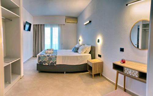 Habitación de hotel con cama y espejo en Aquamare Lesvos en Mithimna