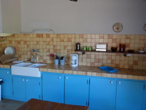 cocina con armarios azules y encimera de azulejos en Marengo, 