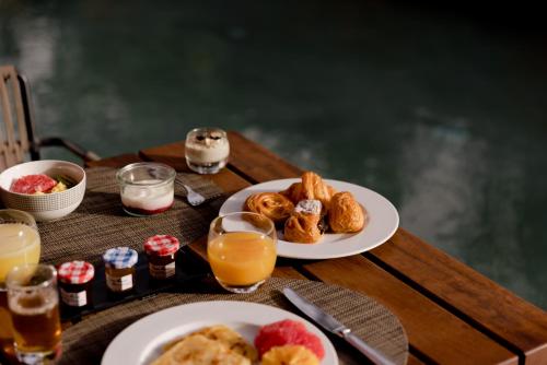 a table with two plates of breakfast foods and orange juice at Nobu Hotel Marrakech in Marrakech