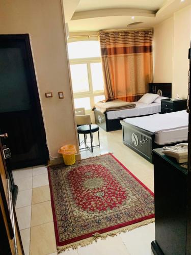 a room with two beds and a flat screen tv at Solitaire Plaza Hotel-Ismailia Train Station in Ismailia