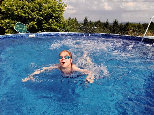 uma mulher numa piscina usando óculos de sol em Zagroda na Pacanach em Iwkowa