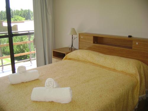 a bedroom with a bed with two towels on it at Chalet en Valle Grande - En Solar del Valle Country Club in Valle Grande