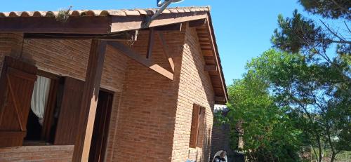 una casa de ladrillo con techo de madera en Casa barrio country, en La Paloma