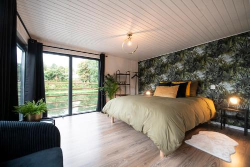 ein Schlafzimmer mit einem großen Bett und einem großen Fenster in der Unterkunft Gîte Seine & Nature Le Bâbord in Bennecourt