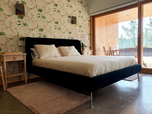 a bedroom with a large bed with a large window at Agroturismo Azkarraga in Amorebieta-Etxano