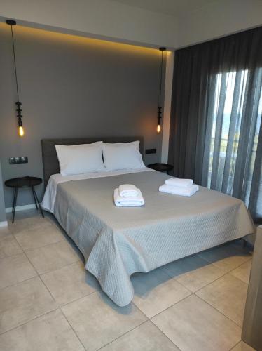 a bedroom with a large bed with two towels on it at doloras_methana in Methana