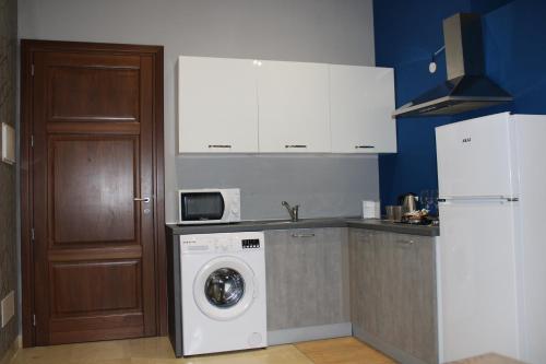 a kitchen with a washing machine and a refrigerator at ZIBIBBO SUITES & ROOMS - Aparthotel in Centro Storico a Trapani in Trapani