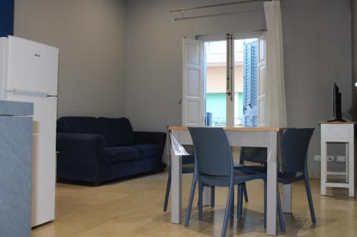 a living room with a table and chairs and a blue couch at ZIBIBBO SUITES & ROOMS - Aparthotel in Centro Storico a Trapani in Trapani