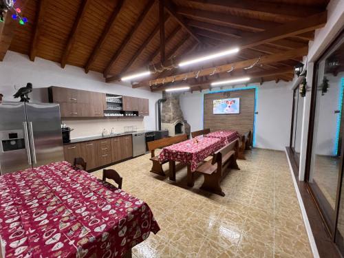 een keuken met 2 tafels en een koelkast in een kamer bij Къщи за гости Фантазия in Dospat