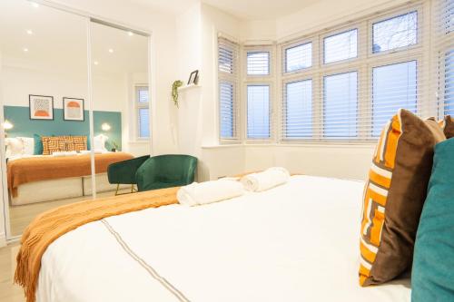 - une chambre avec 2 lits et un miroir dans l'établissement A beautiful one bedroom flat with garden & parking, à Mill Hill