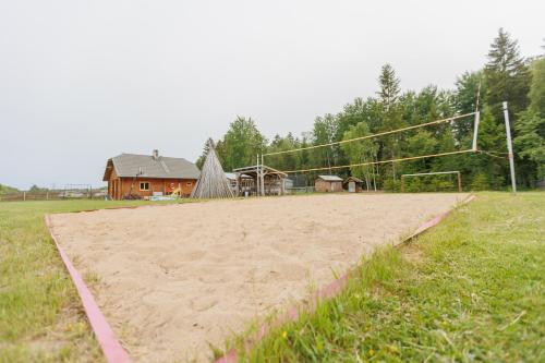 a sandy volleyball court with a goal in a field at Kajamaa Holiday Home in Saku