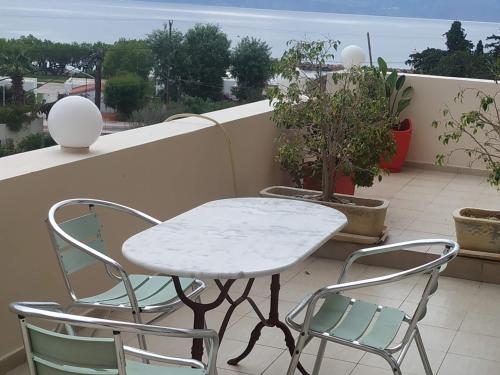 uma mesa e cadeiras numa varanda com vista para o oceano em Family House em Agios Nikolaos