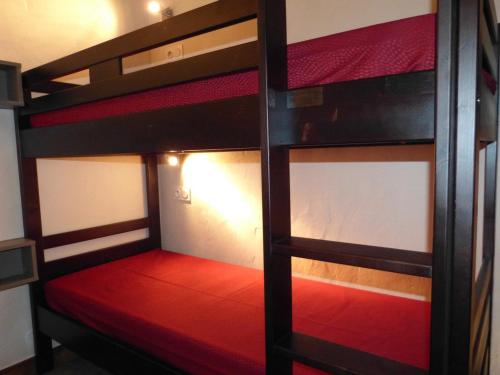 Ce lit superposé se trouve dans un dortoir doté d'un matelas rouge. dans l'établissement Studio cozy aux pieds des pistes, balcon, animaux admis - FR-1-181-2575, à Aime La Plagne