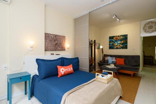 1 dormitorio con 1 cama azul y 1 sofá en Studio a 100m da Praia | NSC 1137/303, en Río de Janeiro